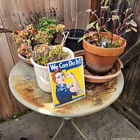 top view of rusted round metal table with planters and Rosie sign