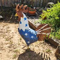 full view of patriotic metal rooster statue standing on ground