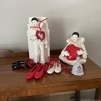 Group shot showing both Pierrot figurines, three pairs ballet slipper ornaments and porcelain bell