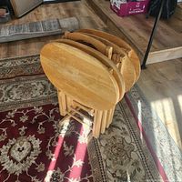 Folded set of four wooden trays in stand on rug