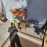 overall lot showing both metal stands, planters, plants and decorative urn