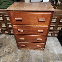 Front view of tall wooden dresser with four drawers and wooden pulls