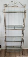 Full view of metal and glass shelf rack showing overall structure and all shelves