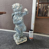 front view of cement cherub angel statue with soda can for scale
