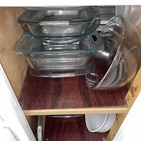 stacked clear glass baking dishes and mixing bowl in cabinet