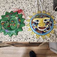 Front view of green and multicolored glazed sun plaques