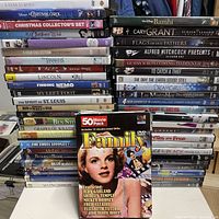 Overall view of stacked DVDs showing variety of titles and 50-Movie Pack