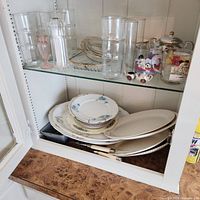 Cabinet view showing entire assortment of glassware and stacked plates