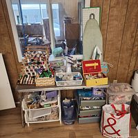 Overall view of folding table, thread rack, storage drawers, ironing board, tote