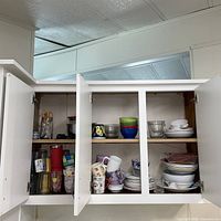 Cabinet view of multiple shelves showing dishes and glassware