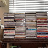 Front view of five vertical stacks of CDs on a wooden table