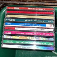 Stack of jewel-case Christmas CDs showing spines for title identification