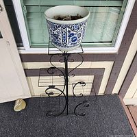 Tall scrollwork stand with Delft planter displayed