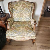 Front view of floral upholstered wingback armchair