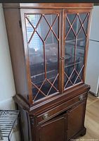 Front view of mahogany china cabinet showing glass doors with lattice and lower storage