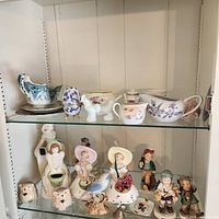 Entire cabinet shelf showing porcelain tableware and figurines
