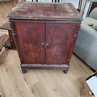 Front view of vintage wood record cabinet showing doors, columns, wear on top