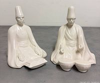 Front view of both seated porcelain dervish figurines