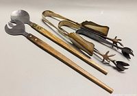 Salad servers and three tongs grouped