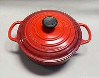 Top view of red Le Creuset dutch oven with lid and handles