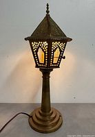 Lamp illuminated, showing pierced lantern head and base