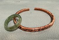 Copper cuff and jade ring together to show lot contents and scale