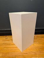 Front angled view of white painted wood pedestal