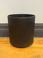 Front view of black ribbed plastic planter