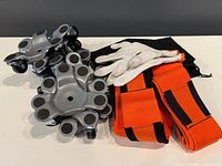 group shot of four tri-wheel dollies, two lifting straps and work gloves