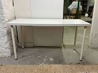 Full view of white table against wall showing four legs