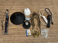 Group shot of all lamp parts, cords, hardware and power strips laid out on carpet