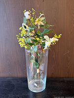 Full view of clear glass vase with artificial floral arrangement