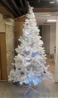 Full view of assembled white tree with blue lights and stand