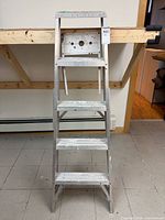 Front view of aluminum step ladder showing four steps and top platform