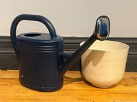 Watering can next to planter showing both items