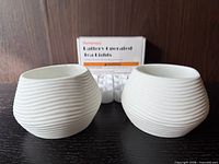 Two ribbed white ceramic planters with Homemory tealight pack behind