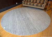 Full overhead view of round grey rug on wood floor