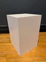 Front angled view of white pedestal cube