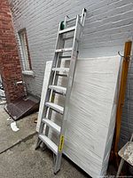 Full view of ladder leaned against wall