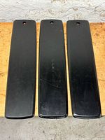 Three black wood boards laid side by side on work surface