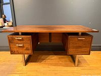 Front view showing floating top, twin drawer pedestals, metal legs