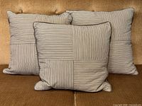 Three striped pillows grouped on sofa front view