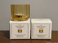 Both boxed tealight holders, one unboxed resting atop packaging