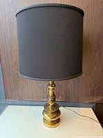 Full view of brass table lamp with black shade