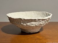 Side view showing overall form and texture of white papier-mâché bowl
