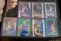 Seven sleeved Panini Prizm basketball cards in binder page
