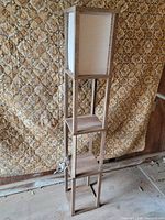 Full view of wooden 3-tier shelf floor lamp with canvas shade