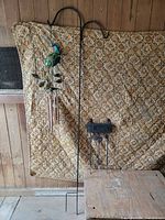 Full view of shepherd’s hook, welcome sign, and peacock wind chime together