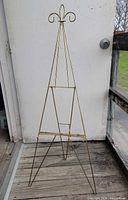 Full view of brass wire easel standing on deck