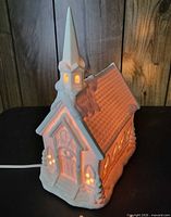 Front view of ceramic church lit, showing entrance, steeple and glow